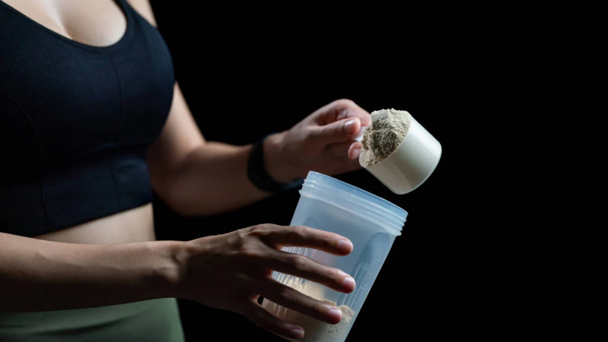 Menyiapkan bubuk kreatin ke dalam shaker untuk suplemen latihan.