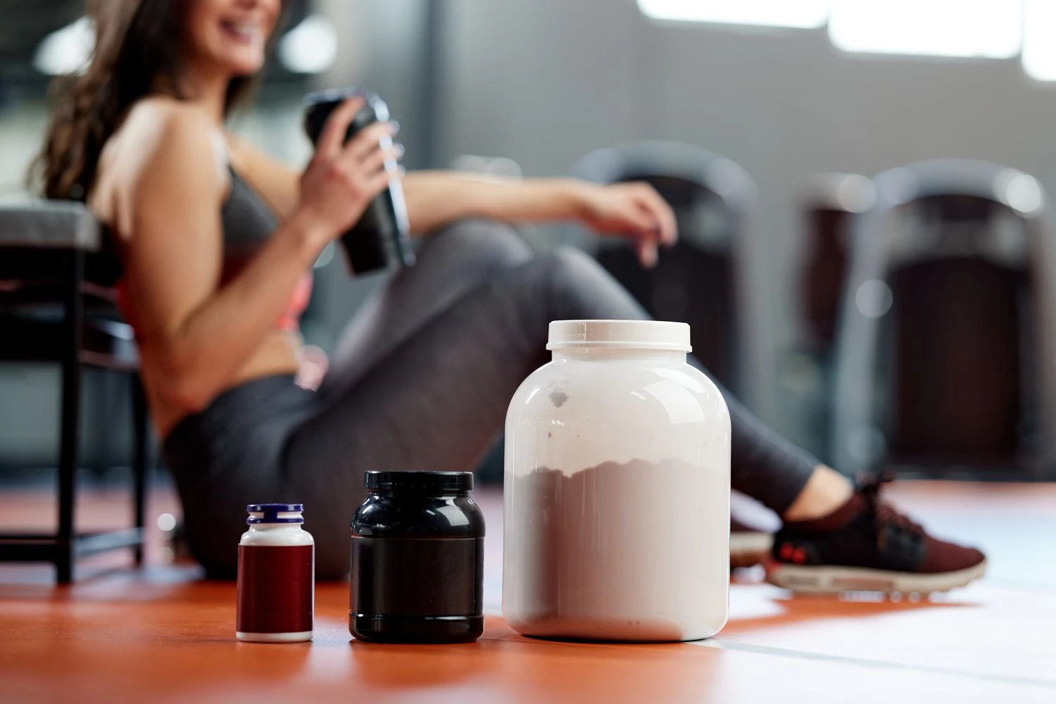 Berbagai jenis kreatin dalam botol suplemen di lantai gym.