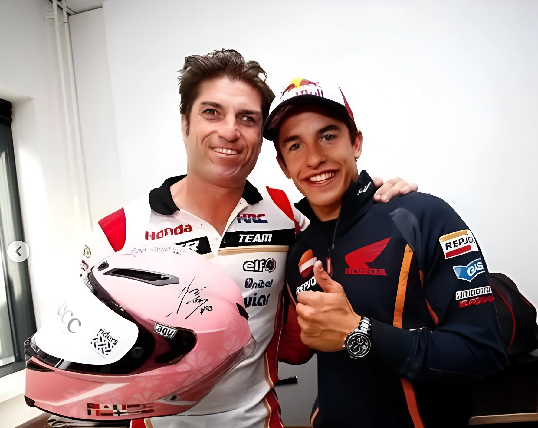 Oscar Haro memegang helm pink sambil berfoto dengan Marc Marquez, pembalap Repsol Honda MotoGP