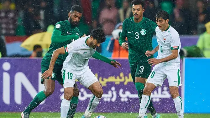 Timnas Irak berhasil menaklukkan Arab Saudi dengan skor 2-0 pada Senin malam di Stadion Internasional Basra yang nyaris tergenang akibat hujan deras. Kemenangan ini membawa Irak ke puncak klasemen Grup A Piala Teluk Arab. (Twitter/@AGCFF)
