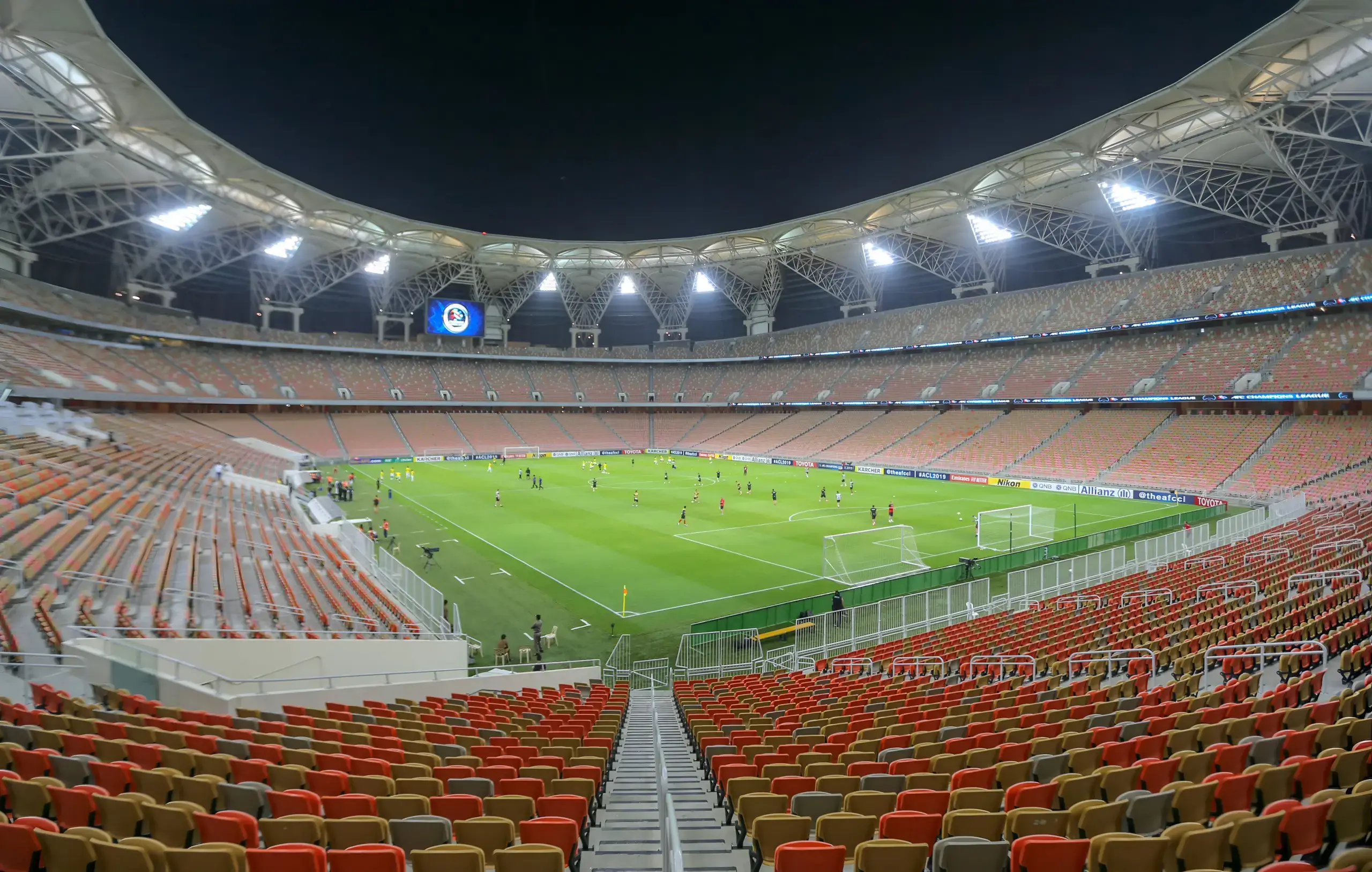 Pemandangan luas stadion King Abdullah Sports City di Jeddah, Arab Saudi, saat pertandingan sepak bola malam hari berlangsung.